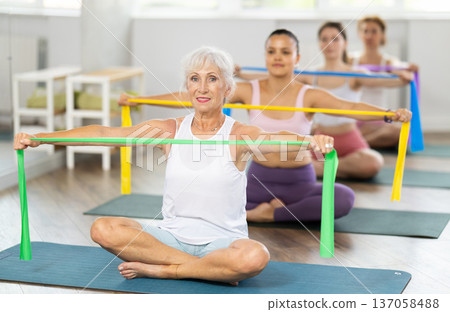 Elderly woman exercises with pilates band Elderly woman exercises with pilates band 137058488
