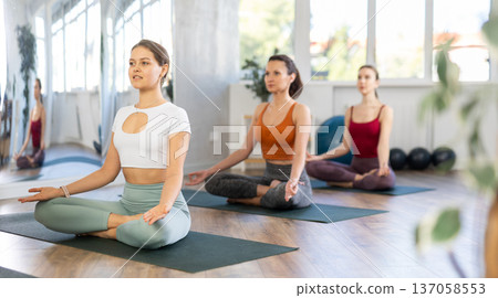 Young girls making yoga meditation in lotus pose in fitness studio 137058553