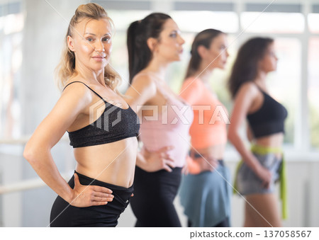 Female participants of project stand in row and perform dance in heels. 137058567