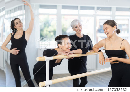 Women students of ballet studio chat sweetly during break, after end of workout. Women students of ballet studio chat sweetly during break, after end of workout. 137058582