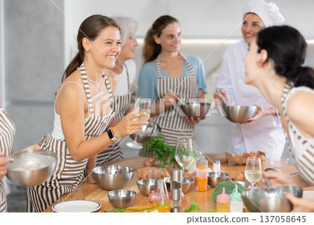 Young woman talks and drinks with group during master class 137058645