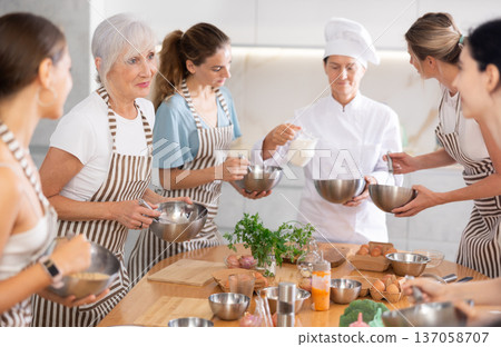 Elderly woman teaching cooking to group of woman 137058707