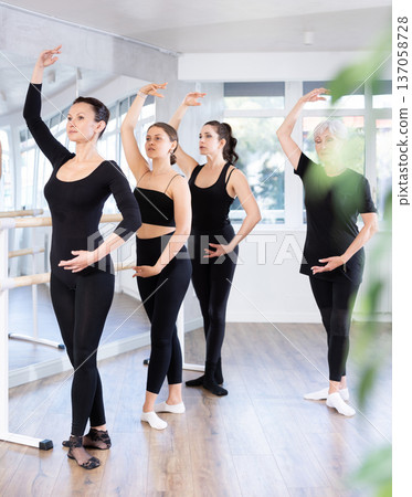 Fit woman maintaining fourth position during ballet workout 137058728