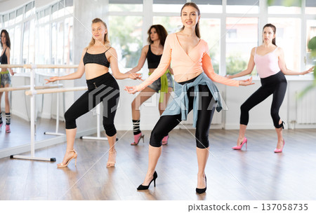 Woman performing high heels choreography during group class 137058735