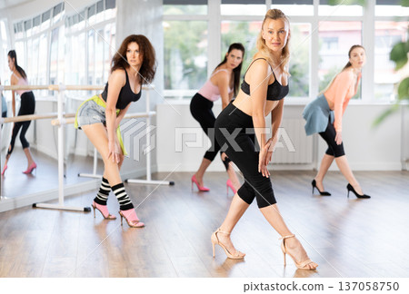 During lesson, woman learn to move and perform dance in heels with women companions 137058750