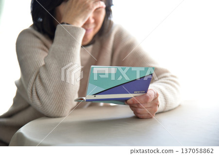 Seniors checking their savings passbook Seniors checking their savings passbook 137058862