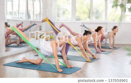 Elderly woman exercises with pilates band Elderly woman exercises with pilates band 137058901