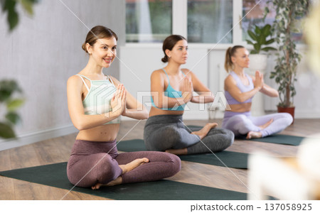 Woman sitting in Padmasana position with hands in namaste 137058925