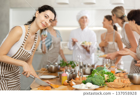 Young woman cutting raw chicken breast Young woman cutting raw chicken breast 137058928