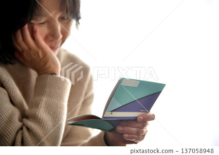 Seniors checking their savings passbook Seniors checking their savings passbook 137058948