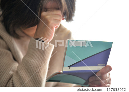 Seniors checking their savings passbook Seniors checking their savings passbook 137058952