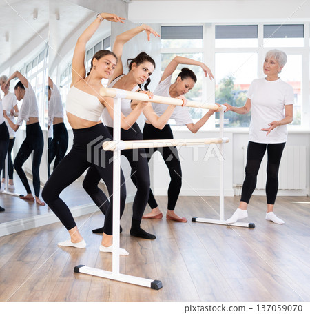 Elderly woman teacher corrects female dancers 137059070