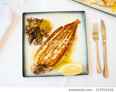 Fried sole fish with baked vegetables and lemon Fried sole fish with baked vegetables and lemon 137059109