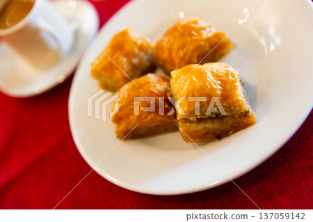 Traditional Turkish dessert - baklava on a plate and cup of coffee Traditional Turkish dessert - baklava on a plate and cup of coffee 137059142