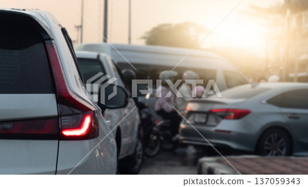 Abstract rear side view of white car open light brake. Front of car several cars prepare in a U-turn area. Traffic is congested during rush hour with both cars and motorcycles going to work or school. Abstract rear side view of white car open light brake. Front of car several cars prepare in a U-turn area. Traffic is congested during rush hour with both cars and motorcycles going to work or school. 137059343