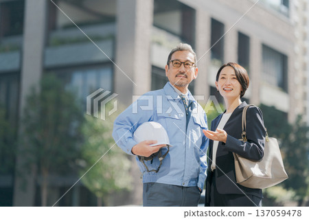 男士身著工作服,女士身著西裝。 男士身著工作服,女士身著西裝。 137059478