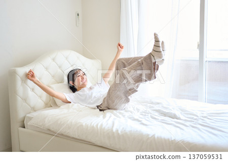 Woman jumping into bed Woman jumping into bed 137059531