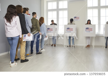 American citizens standing in queue at vote center going to put ballots in bin on election day. American citizens standing in queue at vote center going to put ballots in bin on election day. 137059835