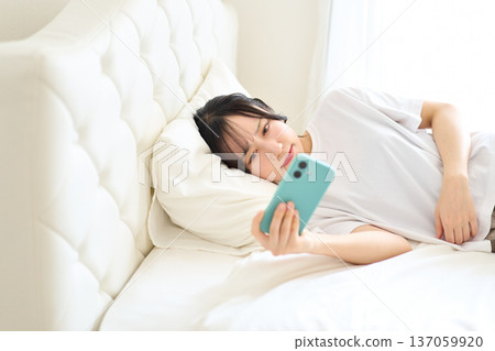 Woman watching videos on a smartphone 137059920