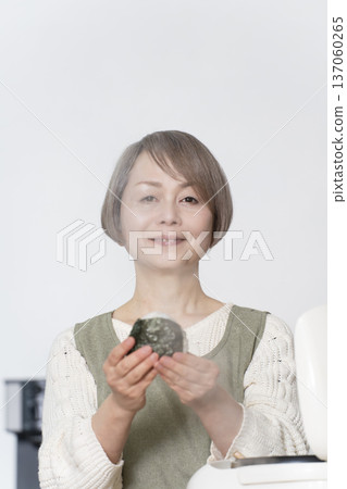 Senior woman making rice balls in the kitchen Senior woman making rice balls in the kitchen 137060265