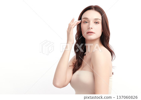 A beautiful young woman with clean, fresh skin against a white background. Skincare, facial treatment, cosmetology, beauty, and spa. An elegant portrait of an woman. 137060826