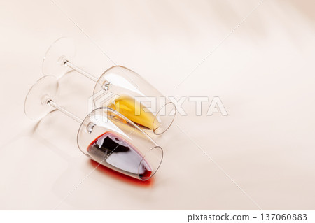 Wine glasses with red and white wine lying on beige background Wine glasses with red and white wine lying on beige background 137060883