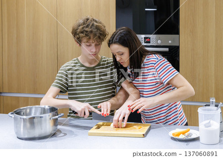 Mother teaching son cooking at home Mother teaching son cooking at home 137060891
