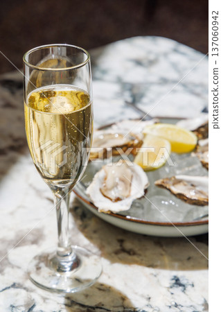 Fresh oysters on ice with champagne in sunlight Fresh oysters on ice with champagne in sunlight 137060942