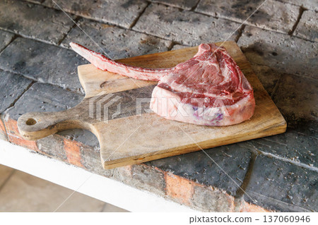 Raw tomahawk steak on cutting board Raw tomahawk steak on cutting board 137060946