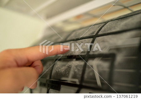 Touching the dust on the air conditioner filter with your fingers 137061219