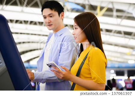 A couple operating a machine at the airport ■Photography cooperation: Kansai International Airport (KIX) 137061307