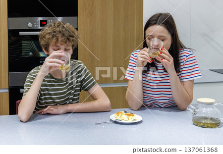 Mother and son drinking tea at home Mother and son drinking tea at home 137061368
