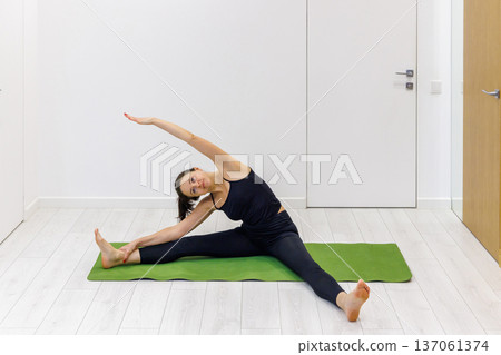 Woman practicing yoga at home Woman practicing yoga at home 137061374