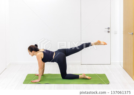Woman practicing yoga at home Woman practicing yoga at home 137061375