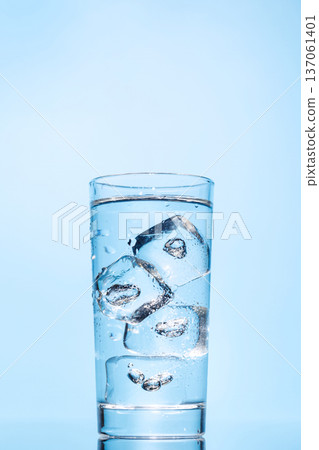 A clear glass filled with chilled water and ice cubes, creating a refreshing and cool drink A clear glass filled with chilled water and ice cubes, creating a refreshing and cool drink 137061401