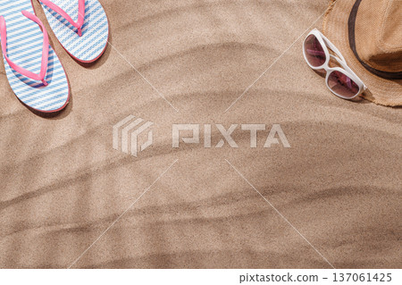 A tropical summer background featuring soft beach sand with delicate palm leaf shadows and sunhat 137061425