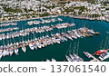 Aerial view of Bodrum marina filled with luxury yachts and sailboats surrounded by white houses and green hills. Popular Mediterranean travel destination in Turkey. 137061540