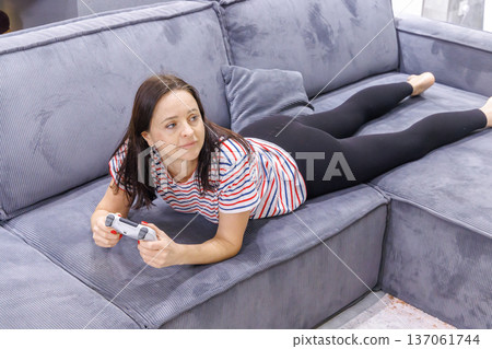 Woman playing console game at home Woman playing console game at home 137061744