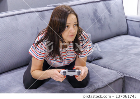 Woman playing console game at home Woman playing console game at home 137061745