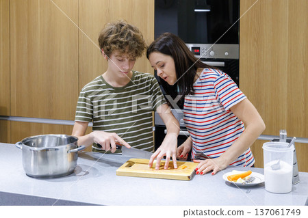 Mother teaching son cooking at home Mother teaching son cooking at home 137061749