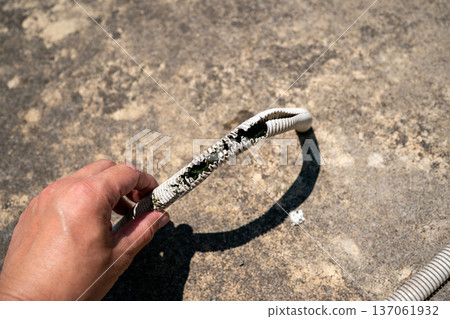 The air conditioner drain hose had deteriorated and cracked. 137061932