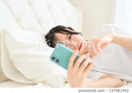 A woman looking at a smartphone with an uneasy look A woman looking at a smartphone with an uneasy look 137061942