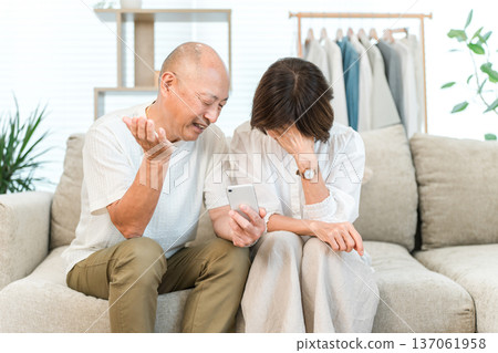 Senior couple frustrated and at a loss because they don't know how to use their smartphone Senior couple frustrated and at a loss because they don't know how to use their smartphone 137061958