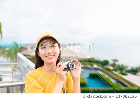 Woman with a camera at the resort Woman with a camera at the resort 137062150