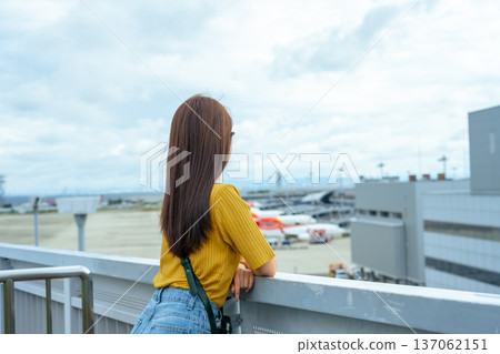 A woman watching the planes from the observation deck. Photo courtesy of Kansai International Airport (KIX). A woman watching the planes from the observation deck. Photo courtesy of Kansai International Airport (KIX). 137062151