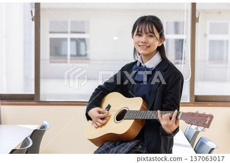 Female student playing guitar Female student playing guitar 137063017