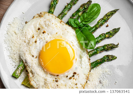 Fried egg with green asparagus and grated parmesan cheese for healthy breakfast Fried egg with green asparagus and grated parmesan cheese for healthy breakfast 137063541