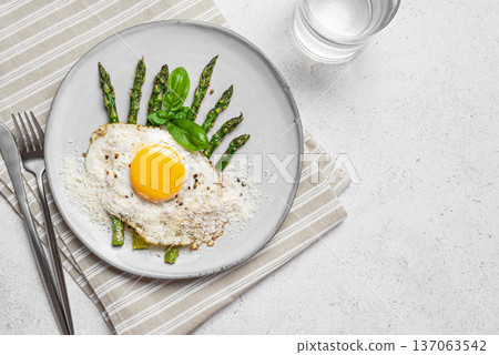 Fried egg with green asparagus and grated parmesan cheese for healthy breakfast Fried egg with green asparagus and grated parmesan cheese for healthy breakfast 137063542