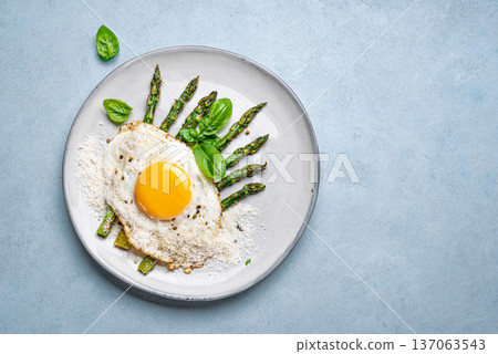 Fried egg with green asparagus and grated parmesan cheese for healthy breakfast 137063543