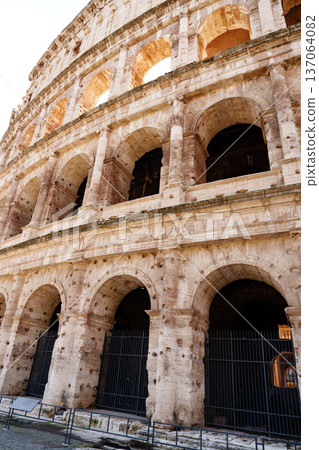 Views of the Colosseum in Rome showing its stone structure and arches during daylight Views of the Colosseum in Rome showing its stone structure and arches during daylight 137064082